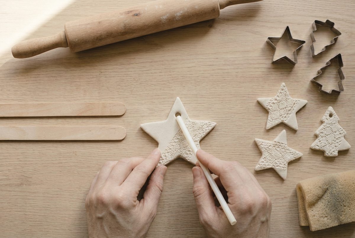 A drinking straw punching a hanging hole in a clay star ornament