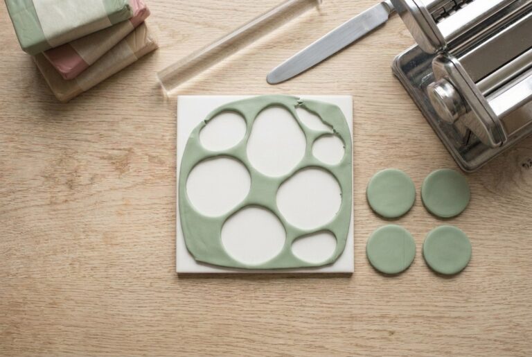 A smooth conditioned sheet of green polymer clay with cut pendant shapes
