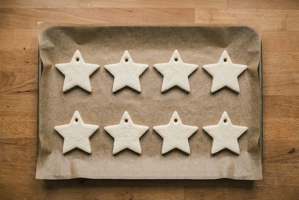 Cut salt dough stars spaced out on a parchment-lined baking tray